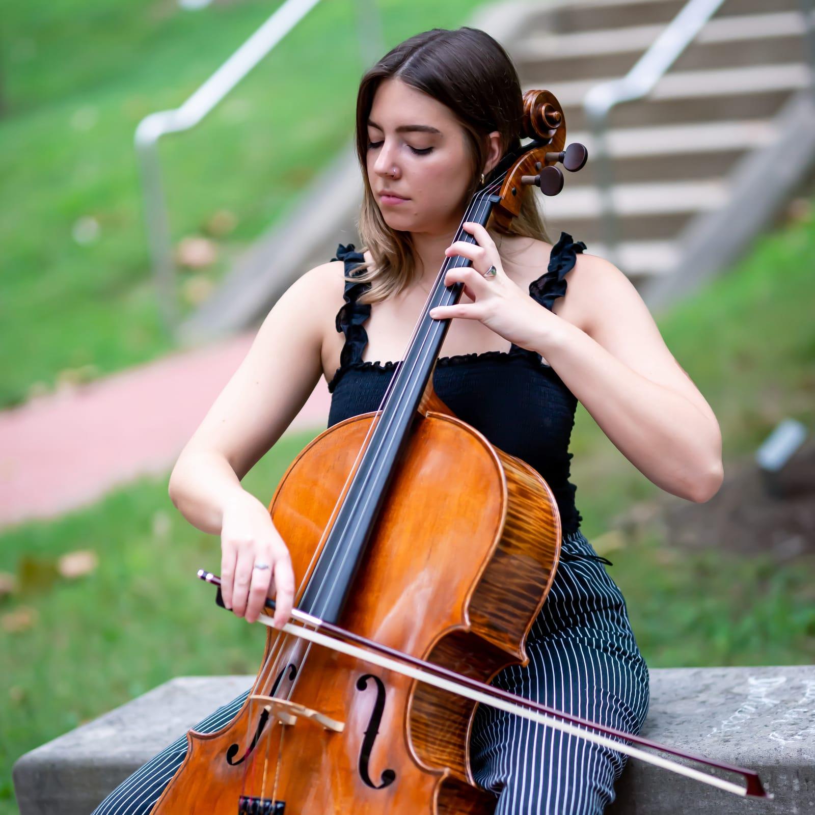 Olivia Hunt playing cello outdoors